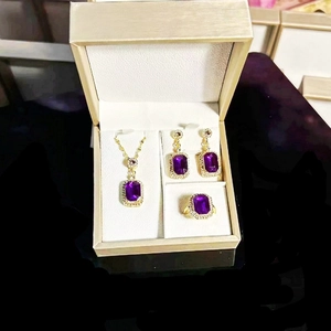 Detailed set of purple emerald-cut gemstone necklace, earrings, and ring in gold