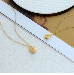 Detailed close-up of 18K gold plated necklaces featuring starburst engraved pendants