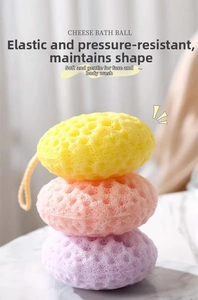 Close-up of cheese-shaped honeycomb bath sponges in yellow, pink and purple with hanging rope