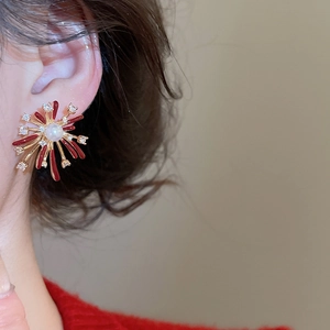 Detail of firework shaped stud earring with pearls and rhinestones on a female model