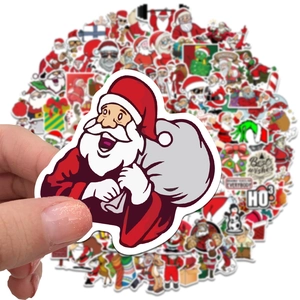 Close-up of a Santa Claus sticker being held over a pile of assorted Christmas decals