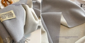 Close-up of double-sided cashmere-like scarf with fringe and minimalist brand label