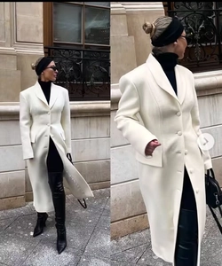 Detail of a slim-fit white wool coat with a classic lapel and single-breasted button design