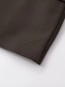 Close-up detail of dark brown woven fabric texture and smooth hem on women's blazer