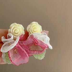 Close-up of floral drop earrings with mesh petals and colorful crystal beads