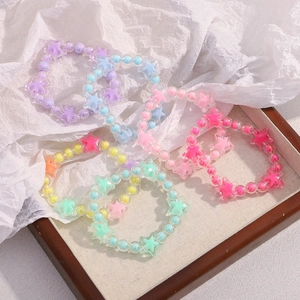 Detailed arrangement of colorful star beads bracelets on textured paper background