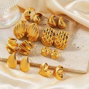 Golden geometric stainless steel earrings set featuring textured metal designs on silk