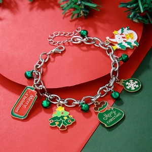 Macro detail of Christmas charm bracelet with Santa and tree charms on festive background