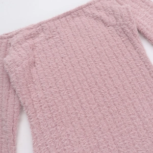 Gros plan sur la texture du tricot duveteux rose doux de la robe moulante sexy
