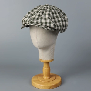 Detailed macro view of the dark green and white checkered linen newsboy cap fabric texture