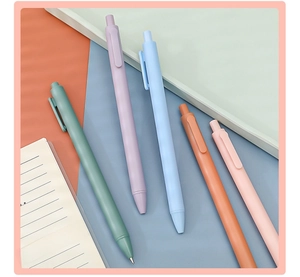 Close-up of a 5-piece set of Morandi colored retractable gel pens on an office desk