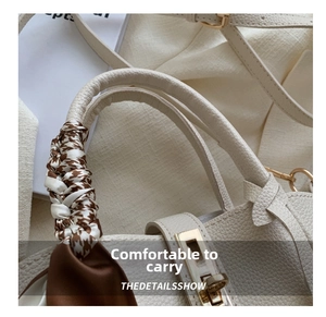 Détail de la poignée du sac en cuir blanc avec foulard en soie et fermoir doré rotatif