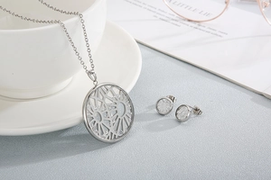 Detail view of round hollow mirror pendant necklace and earring set with cubic zirconia