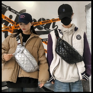 Street style shot of silver and black quilted waist bags on models with urban graffiti background