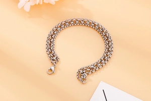 Detail view of triple-layer silver stainless steel pearl chain bracelet with lobster clasp