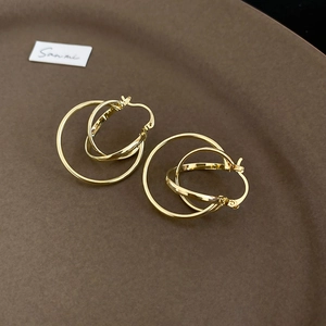 Macro detail of layered golden interlocking circular earrings with a polished finish