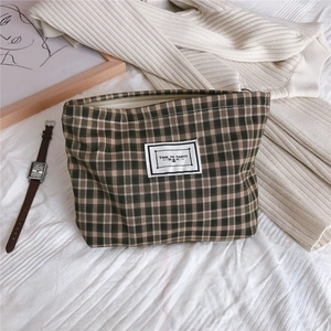 Macro shot of retro green plaid canvas pouch with Time to Party patch and zipper