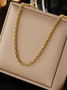 Close-up of gold twist rope chain necklace displayed on a beige jewelry gift box