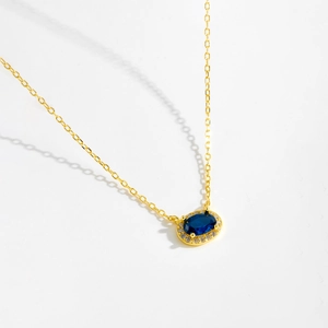 Macro shot of s925 silver necklace featuring a blue oval gem and white zircon halo