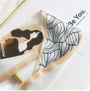 Close-up of a satin silk scarf with modern portrait print on a minimalist background