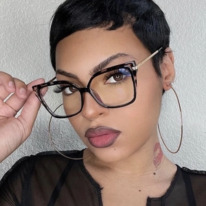 Close-up of tortoise shell square glasses frame on a model with gold hoop earrings
