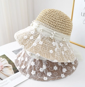 Close-up of floral lace crochet straw hat with pearl accents and delicate embroidery