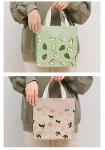 Close-up of portable canvas tote bags in avocado green and peach pink fruit prints