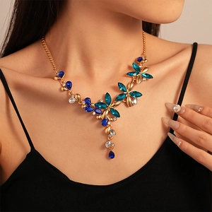 Close-up of vintage flower necklace with blue crystals on model in black top