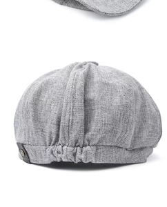 Detail of light gray linen newsboy cap showing fabric texture and elastic adjustment