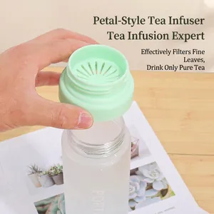 Portable frosted plastic water bottle with a green petal tea infuser on a wooden desk