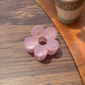 Gros plan détaillé d'une pince à cheveux fleur rose de 5cm en résine sur bois
