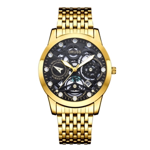 Detail of waterproof gold metal watch with black skeleton dial and calendar window