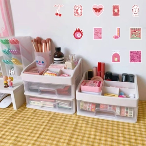 Pink retro stickers on wall behind a white plastic desk organizer with clear drawers