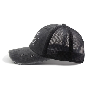 Close-up of be kind embroidery and distressed brim on the black mesh baseball cap