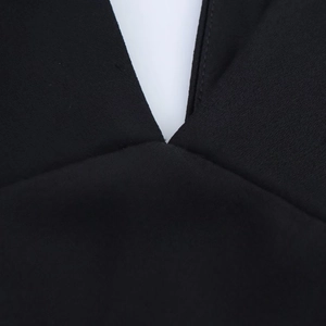 Détail de la couture du col en V et de la texture satinée soyeuse sur une robe noire élégante