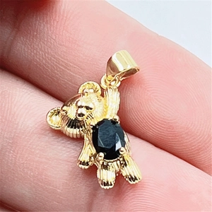Vue détaillée du pendentif ours doré avec incrustation d'une pierre noire ovale