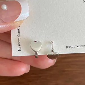 Close-up of heart-shaped 925 sterling silver stud earrings with high-polish finish