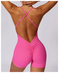 Detail of pink sports bodysuit featuring an open cross-back design and ruched booty detail