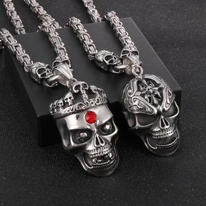 Macro shot of punk gothic skull pendants with red rhinestones on stainless steel chains