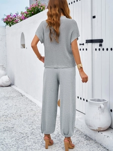 Back view of a casual grey two-piece knit set featuring short sleeves and wide-leg trousers
