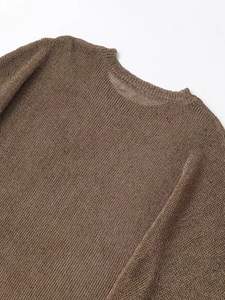 Gros plan détaillé sur la texture tricotée fine et l'éclat marron métallique du pull-over