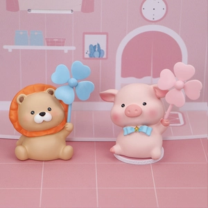 Close-up of cute cartoon resin lion and pig ornaments with colorful clover windmills