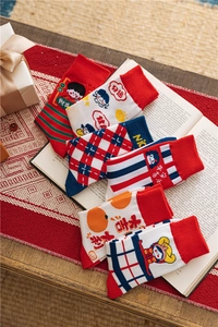 Close-up of festive red and white knitted socks with holiday patterns and Chinese characters