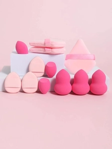 Detailed set of eleven pink makeup sponges and ribbon puffs on geometric blocks