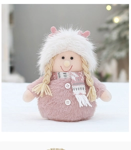 Detail of pink plush Christmas doll with fluffy white hat and festive snowflake scarf