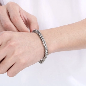 Macro detail of men's stainless steel keel chain bracelet with vintage woven pattern