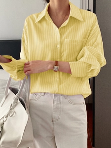 Detail of yellow striped long sleeve shirt featuring a button-down collar and relaxed fit