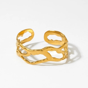 Bracciale rigido dorato aperto minimalista con trama lavica irregolare in studio