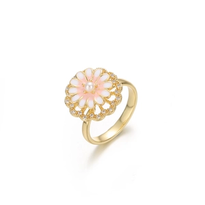 Macro shot of gold floral ring with white pearl center and enamel petals and crystals