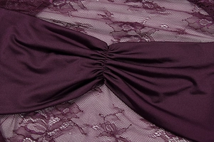 Detail view of plum purple dress showing gathered satin and floral lace textures